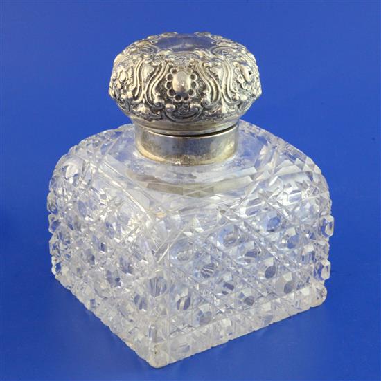 A large late Victorian repousse silver lidded cut glass inkwell, 6in.